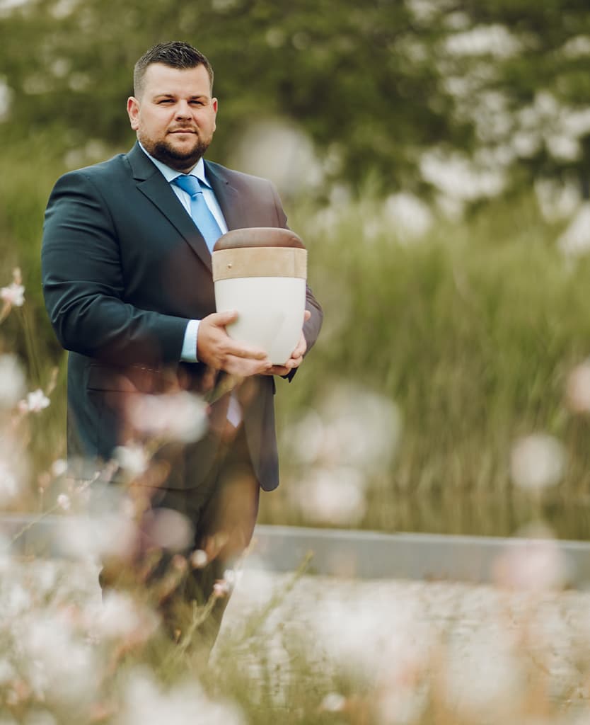 Maximilian Littig mit einer Urne in der Hand
